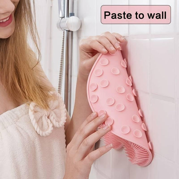 Woman pressing pink Back & Foot Scrubber | Dreambox Beauty with suction cups against a shower wall for easy mounting and hands-free exfoliation.
