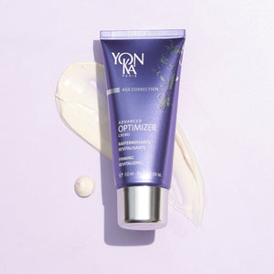 Tube of Advanced Optimizer Crème - Anti-Aging, Firming Cream I Yon-Ka Paris with cream texture swatched on light surface, showcasing skincare product for firming and revitalizing.