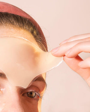 Close-up of a person applying the Skin Plumping Reusable Forehead Pad | Dreambox Beauty to their forehead, demonstrating a skincare wellness device for hydration and smoothing.