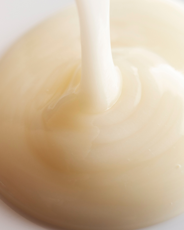 Close-up of creamy, milky textured cleanser being poured, representing the gentle and hydrating qualities of Harmony Cucumber + Kombucha Microbiome Milky Balancing Cleanser | Three Ships for skincare.