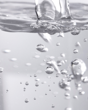 Close-up of clear liquid bubbles rising in water, representing the fresh and hydrating qualities of Fresh Start Lime Pearl + Prickly Pear 5% PHA Resurfacing Treatment | Three Ships skincare product.