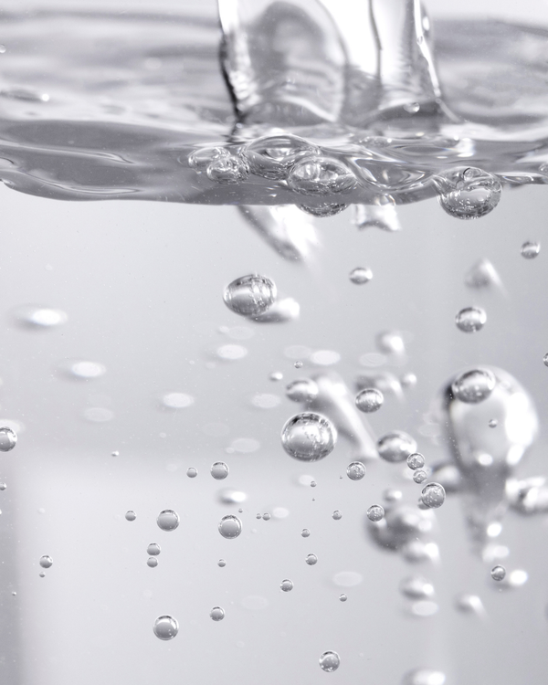 Close-up of clear liquid bubbles rising in water, representing the fresh and hydrating qualities of Fresh Start Lime Pearl + Prickly Pear 5% PHA Resurfacing Treatment | Three Ships skincare product.