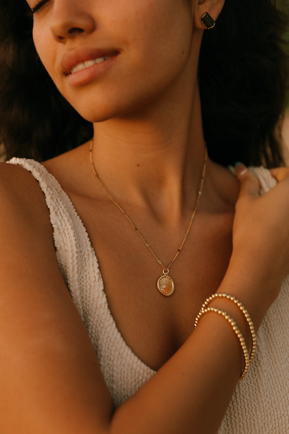 Golden Sunrise Necklace | Meghan Bo featuring a delicate gold chain and round pendant with a sun rising design, symbolizing warmth and new beginnings.
