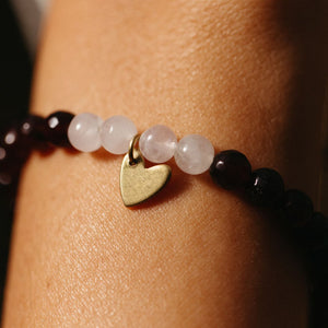 Close-up of a wrist wearing a Gemstone Heart Bracelet | Purpose Jewelry featuring polished round beads and a small gold heart charm.