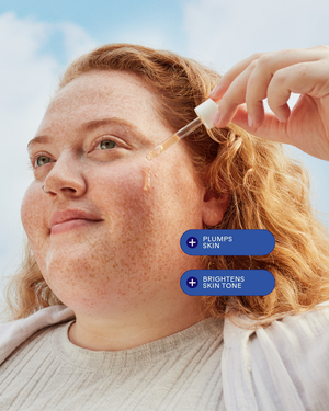 Close-up of a woman applying Dew Drops Mushroom + Kakadu Plum Hyaluronic Acid Serum | Three Ships to her cheek, highlighting its benefits to plump and brighten skin tone for skincare.