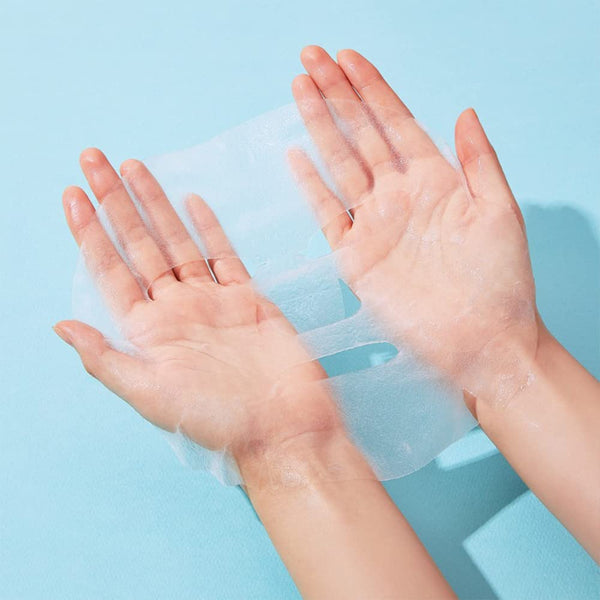 A person holding a translucent, thin sheet mask for skincare on a light blue background, promoting ImPHYTO Ceramide | Leaders for hydration and skin wellness.