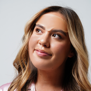 Woman wearing a translucent skin patch on her forehead demonstrating the Skin Plumping Reusable Forehead Pad | Dreambox Beauty for skincare and wellness purposes.