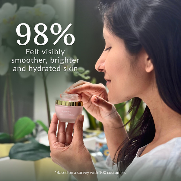 Woman with long dark hair holding a jar of Gheesutra Face Emulsion | Shankara, highlighting 98% of users felt smoother, brighter, and hydrated skin after use in a skincare setting.
