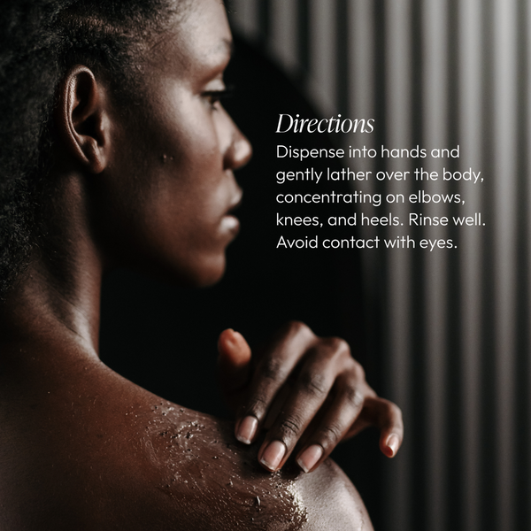 Close-up of a person gently applying Blue Bamboo Exfoliator for Body | Circadia on their shoulder with visible exfoliating texture, accompanied by usage directions in soft lighting.