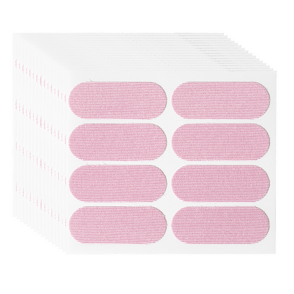 Stack of adhesive pink strips arranged on white backing sheets, designed for skincare use, featuring Face Tape | Dreambox Beauty for gentle and effective facial application.