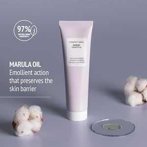 Tube of Remedy Cream to Oil | [ comfort zone ] with marula oil emollient action displayed alongside cotton flowers and clear gel on a glass dish on a soft gray background.