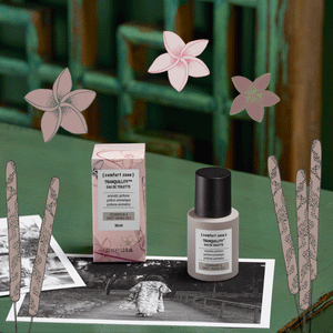 Eau De Toilette | [ comfort zone ] bottle and packaging with calming floral graphics, placed on a vintage black-and-white photograph, evoking a serene and relaxing atmosphere.