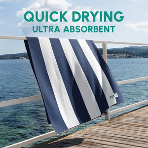 Striped navy and white waffle microfiber beach towel hanging on a wooden railing by the sea with text highlighting quick drying and ultra absorbent features, Waffle Microfiber Beach Towel - Nautical Navy | SUN'Y