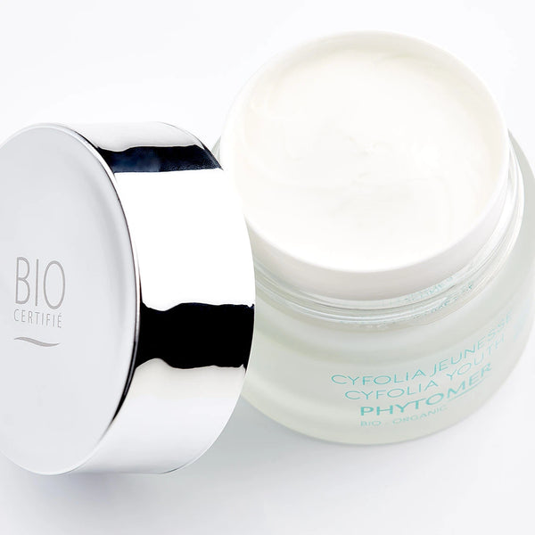 Open jar of Cyfolia Youth Glow Renewing Wrinkle Cream | Phytomer with smooth white cream inside and reflective silver lid labeled BIO certifié on a white background