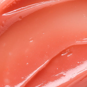 Close-up of glossy, smooth coral-toned balm texture highlighting hydration and softness, representing Hydramemory Plumping Lip Balm | [ comfort zone ] skincare product.