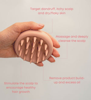 Hand holding a pink scalp scrubber with soft silicone bristles designed to target dandruff, itchy scalp, and dry skin while massaging, cleansing, and stimulating healthy hair growth with the Scalp Scrubber [Revitalizing Scalp Massager] | Dreambox Beauty.
