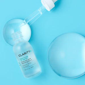 Clear frosted glass dropper bottle of Daily Dose Of Water™ Hyaluronic Acid Hydrating Serum | ClarityRx with serum drops and hydration droplets on a blue background for skincare hydration.