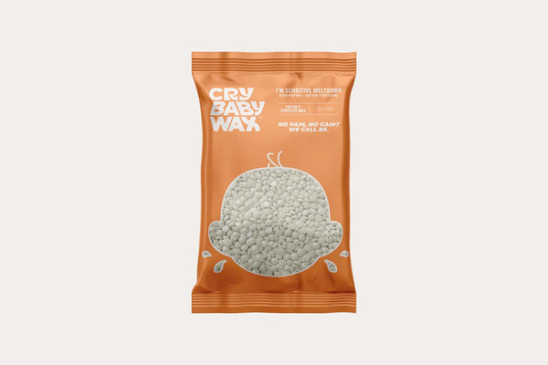 A sealed orange bag of I'm Sensitive Meltdown Vegan Hard Wax | Crybaby Wax featuring a minimalist crying face graphic and bold white text promoting gentle, pain-free waxing.