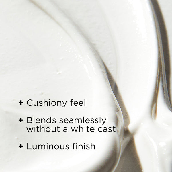 Close-up of creamy white moisturizer texture with text highlighting cushiony feel, seamless blending without white cast, and luminous finish for DAILY PREVENTION Ultra Defense Moisturizer SPF 50 | IMAGE Skincare.