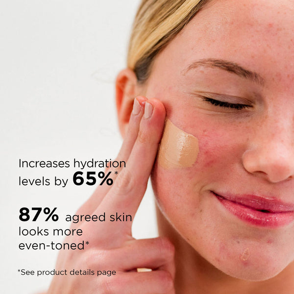 Close-up of a woman applying DAILY PREVENTION pure mineral tinted moisturizer SPF 30 | IMAGE Skincare on her cheek, highlighting improved hydration and even-toned skin benefits.