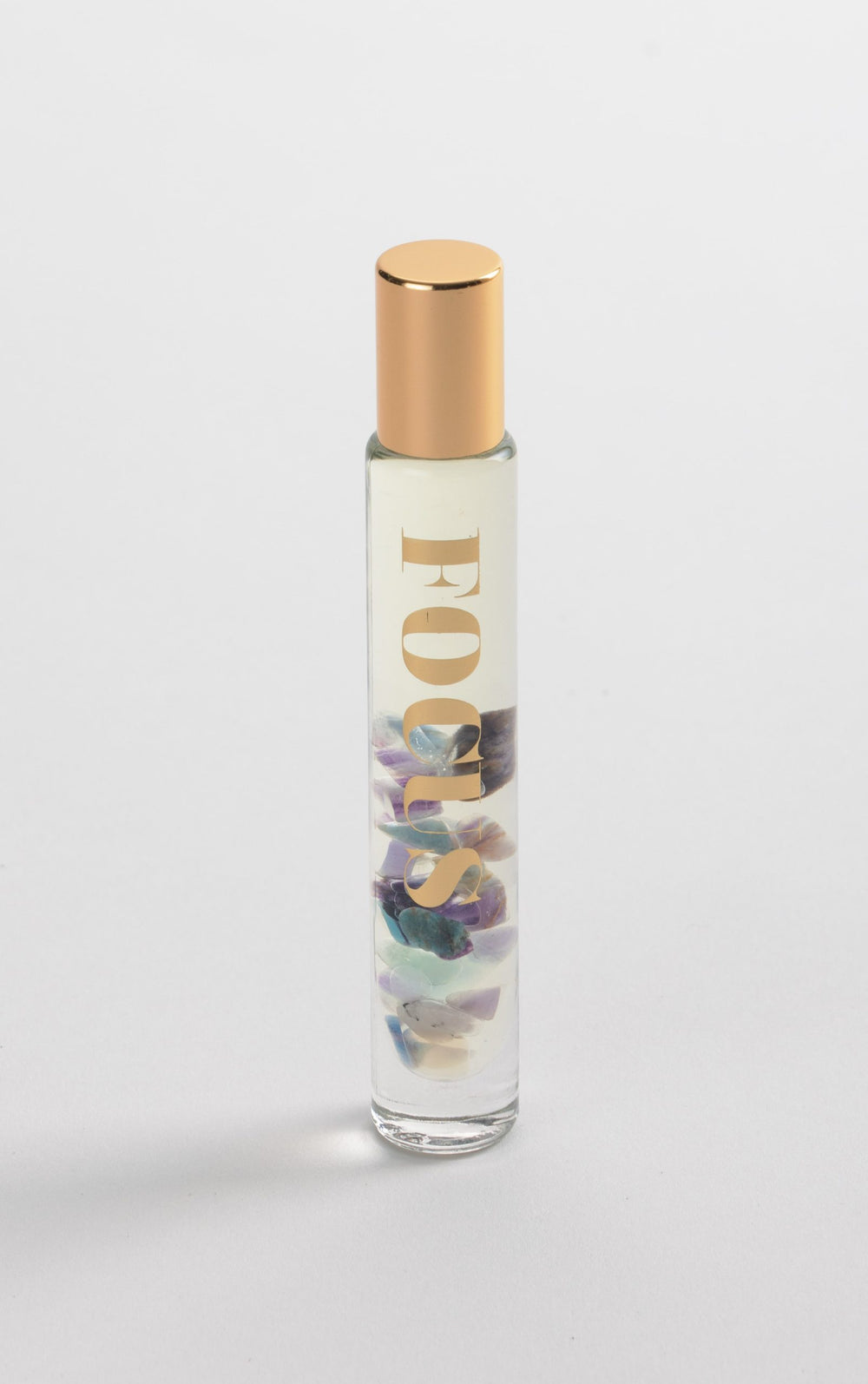 Focus Rollerball | Aluminate Life with fluorite crystal-infused essential oil blend in a clear glass rollerball bottle with gold cap and decorative white and gold packaging.