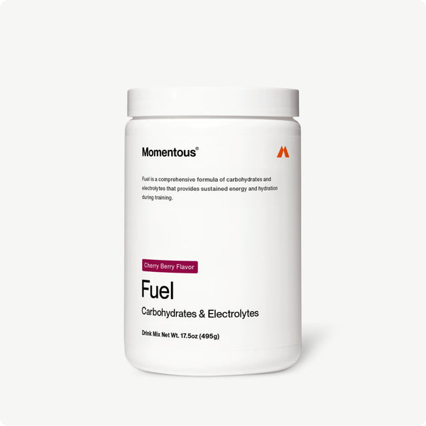 White container of Fuel drink mix labeled carbohydrates and electrolytes in cherry berry flavor for sustained energy and hydration during training.