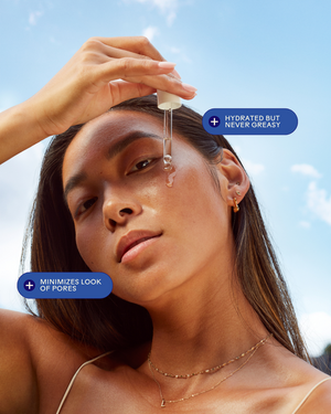 Woman applying Glow 49% Jojoba Oil Serum | Three Ships with a dropper to her face, highlighting hydrated skin that is never greasy and minimized pores against a bright blue sky background.