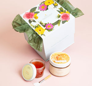 Gift set packaging with floral design featuring two skincare jars and an applicator brush for the Honey I’m Smooth Limited Edition Set | Farmhouse Fresh.
