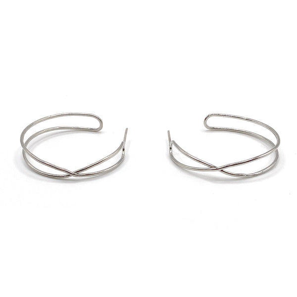 Pair of minimalist silver open hoop earrings with an elegant crisscross design, showcasing the Infinity Hoops | Purpose Jewelry style.