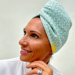 Woman smiling wearing a green textured Microfiber Hair Turban | Popmask, showcasing a comfortable fit ideal for skincare and body care routines.