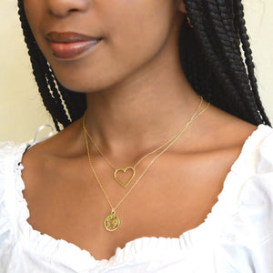 Close-up of a woman wearing the Follow Your Heart Silhouette Necklace (Small / Gold) | Love You More, featuring a delicate gold heart pendant on a fine chain.