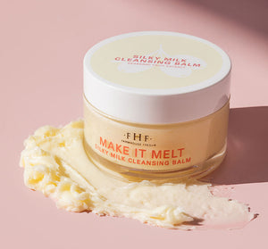 Make it Melt Silky Milk Cleansing Balm | Farmhouse Fresh in a clear jar with a white lid, creamy balm texture smeared on a pink surface, showcasing skincare wellness product.