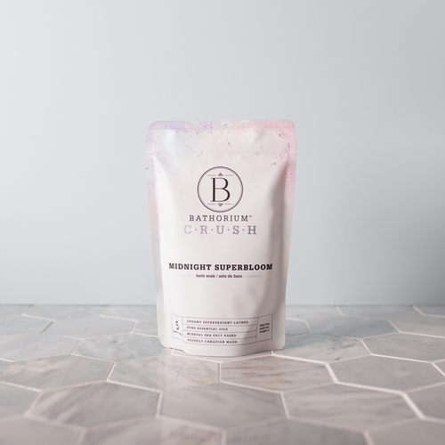 Midnight Superbloom Crush | Bathorium packaging standing on a geometric tile surface, featuring a soft pink and white design for a skincare bath soak product.