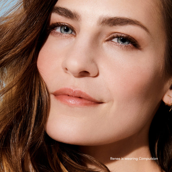 Close-up of a woman with natural makeup and glossy lips showcasing the subtle tint of Beyond Matte® Lip Stain | Jane Iredale in a soft, elegant shade.