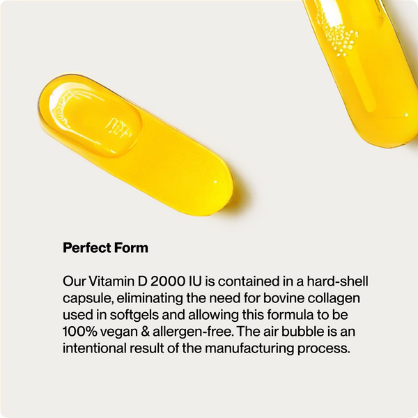 Close-up of two yellow hard-shell capsules containing Vitamin D3 2000 IU with visible air bubbles on a light background, highlighting a vegan and allergen-free wellness supplement.