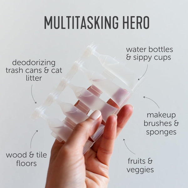 Hand holding a set of clear Activator Capsules 25ct box 12oz/3mL | Force of Nature with text highlighting uses for deodorizing trash cans, cat litter, water bottles, sippy cups, makeup brushes, sponges, fruits, veggies, wood, and tile floors.