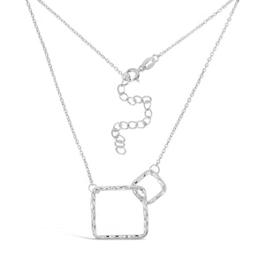 Delicate silver necklace featuring two interlocking hammered squares suspended on a fine chain with adjustable clasp, showcasing the Geometry Squares Necklace | Little Sparkles.