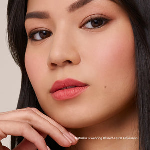 Close-up of a woman with flawless skin and natural makeup, showcasing soft pink matte lips using Beyond Matte® Lip Stain | Jane Iredale.