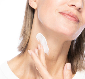 Close-up of a woman applying Necks-Level Smooth™ Cream | Farmhouse Fresh to her neck, demonstrating skincare for smooth, healthy skin.