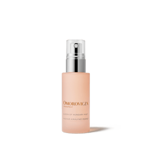Bottle of Queen of Hungary Mist | Omorovicza facial mist with a minimalist design, featuring a soft peach color and a silver spray cap for skincare and wellness.