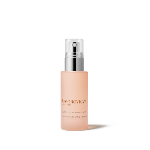 Bottle of Queen of Hungary Mist | Omorovicza facial mist with a minimalist design, featuring a soft peach color and a silver spray cap for skincare and wellness.