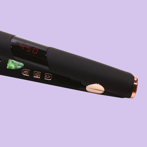 Close-up of the sleek black IR2 Infrared Flat Iron - 1" | SUTRA with digital temperature display and rose gold accents against a lavender background.