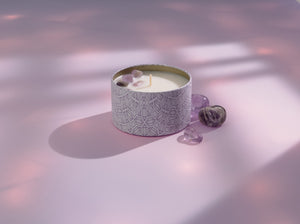 Release Candle Tin 6 oz | Aluminate Life with decorative stones resting on a soft pink surface illuminated by gentle natural light, evoking a calm and soothing atmosphere.