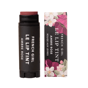 Le Lip Tint | French Girl in Ambre Rose shade, presented in a sleek black tube with matching floral packaging, designed for a natural lip tint effect.