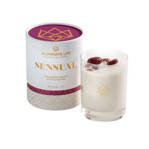 Sensual Glass Candle | Aluminate Life in a clear glass with red crystals on top, accompanied by white and gold elegant packaging for a luxurious wellness experience.