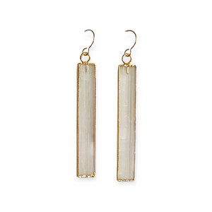 Pair of long rectangular selenite stone earrings with gold-tone metal edging and hooks, styled as elegant and minimal jewelry Selenite Earrings | Meghan Bo.