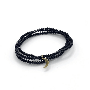 Dusk Stretch Bracelet | Purpose Jewelry featuring black faceted beads wrapped twice with a small crescent moon charm for a sleek, versatile wellness accessory.