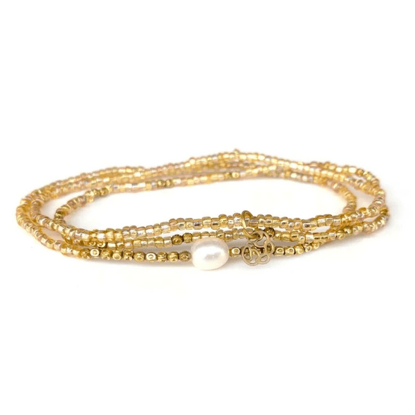 Delicate multi-strand gold beaded bracelet featuring a single white pearl and a small decorative charm, designed as the Tenere Bracelet | Purpose Jewelry.