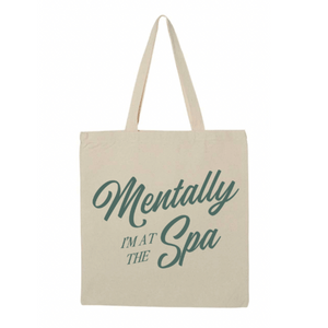 Mentally At The Spa Tote | Lucky Owl featuring a natural canvas tote bag with green script text that reads "Mentally I'm at the Spa," ideal for carrying skincare and wellness essentials.