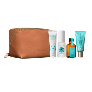 Travel-sized set featuring a brown zip pouch with shower gel, shampoo, hair oil, and hand cream for hair and body care in the Body Travel Hair Set | Moroccanoil.